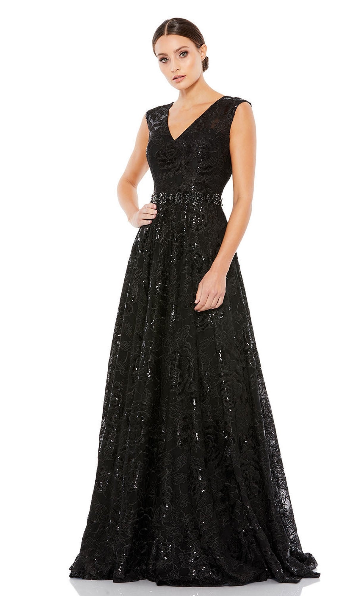 Model wearing the Long Formal Dress 12413 by Mac Duggal—sleeveless, floor-length black gown with v-neckline and sequin embroidery—posed against a white background.